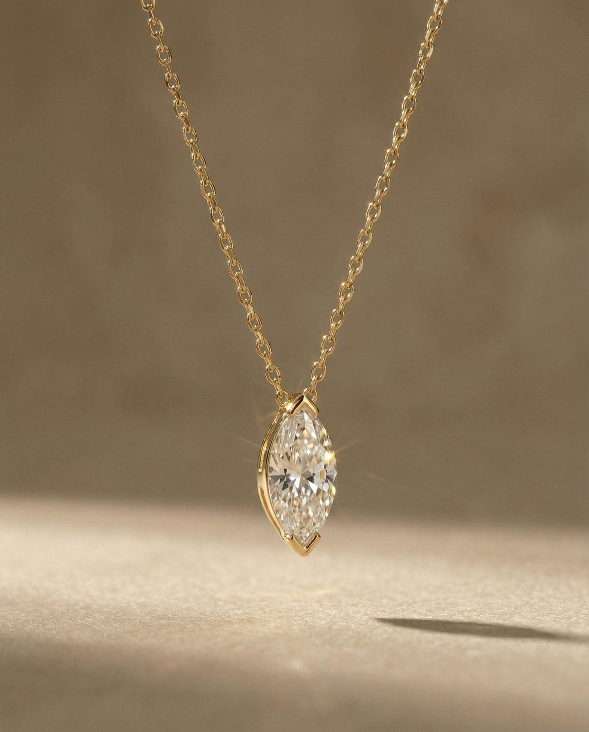 Modern marquise diamond solitaire pendant necklace in solid 18k yellow gold. Minimalist fine jewelry and everyday diamond layering necklace with chevron prong setting.