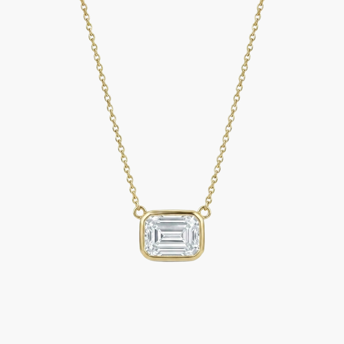 18k yellow gold necklace featuring a 1ct emerald cut diamond set horizontally in a sleek bezel setting. The pendant hangs from a delicate gold cable chain.